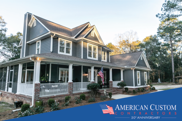 Picture of a colonial style home with new gray vinyl siding and an American flag