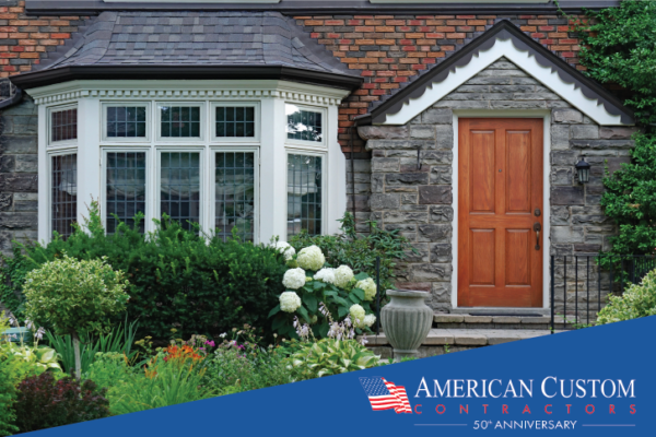 A picture of a large brick home with a 5 pain bay window topped by a peaked mettle roof.