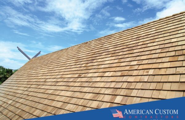 Picture of a natural cedar shake roof peak with a bright blue sky.