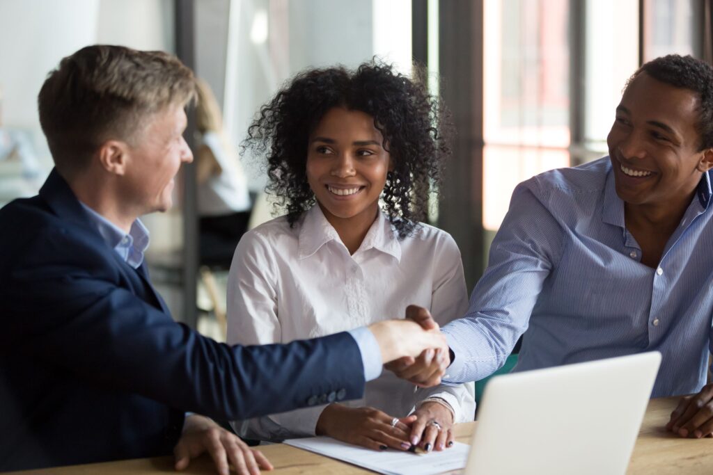 Picture of a couple shaking hands with their insurance adjuster