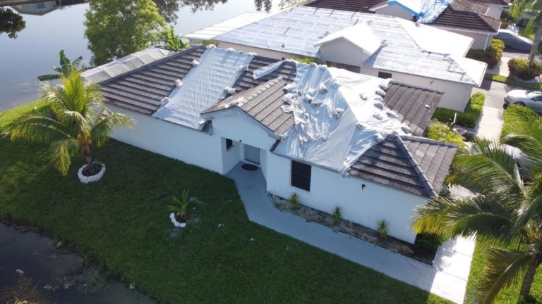 Drone photo of a large home partially covered in WrapRoof.