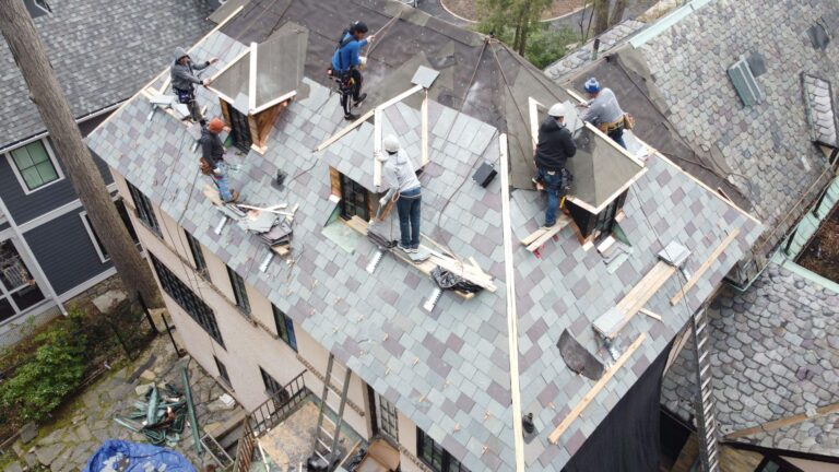 This photo is a birds-eye view of an American Custom Contractors installation crew laying down natural slate in a beautiful Vermont blend which is a mix of green and purple natural slate tiles.