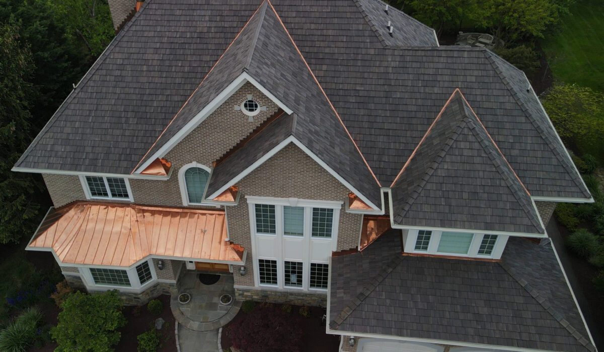 An image taken from a bird's eye view of a 2 story home in Potomac, MD features a Brava synthetic cedar shake tile roof system designed to last 100 years.