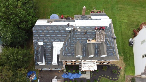 Birds eye drone picture of the top of a house while a new roof is being installed. 