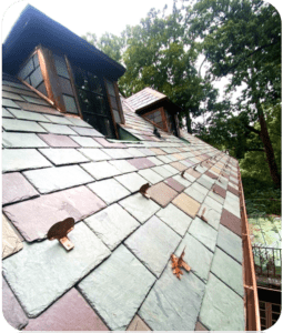 Multicolor natural slate tiles on a roof with copper snow guards