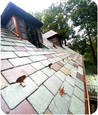Multicolor natural slate tiles on a roof with copper snow guards