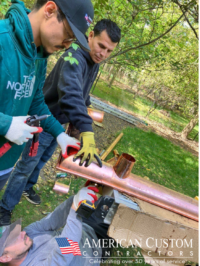We specialize in custom fabrication of our gutter systems. Half round copper gutters are a high end option you will see on many new and historic Washington, DC and Maryland homes. This photo depicts 2 of our tech sawdering together the downspout connection point.