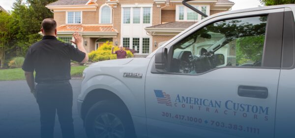 American Custom Contractors truck parked outside a customers large brick home. The owner of the company is waiving to the homeowner as he walks up.