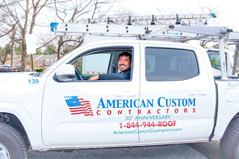 Image of a American Custom Contractors truck with an inspector on his way to give a client roofing, siding, and windows quotes.